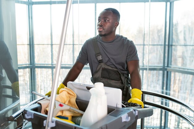 Middellange geschoten man loopt met schoonmaakkar