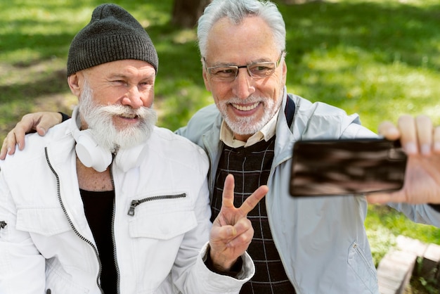 Middellange geschoten oude mannen die selfies maken