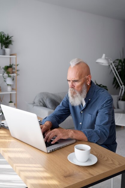 Middellange geschoten senior man met laptop