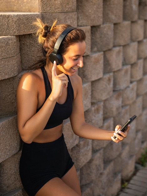 Gratis foto middellange geschoten smileyvrouw die hoofdtelefoons draagt