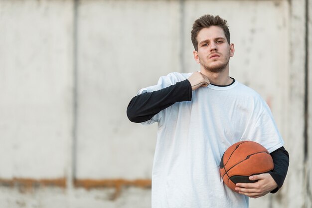 Middellange geschoten stedelijke basketbalspeler die de camera onder ogen ziet