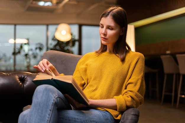 Gratis foto middellange geschoten vrouw die binnen leest