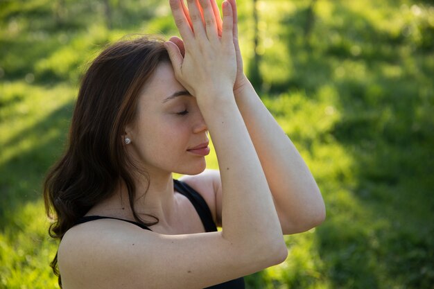 Gratis foto middellange geschoten vrouw die buitenshuis mediteert