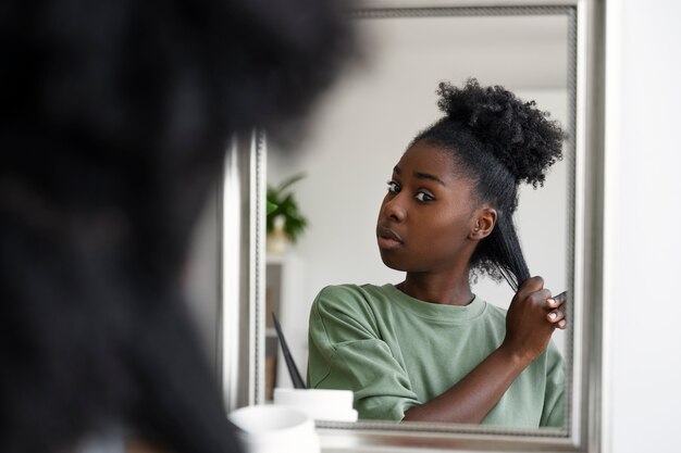 Middellange geschoten vrouw die haar schikt