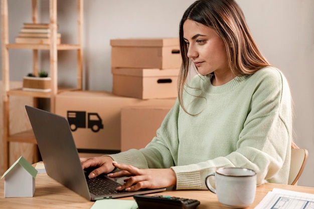 Middellange geschoten vrouw die op laptop typt