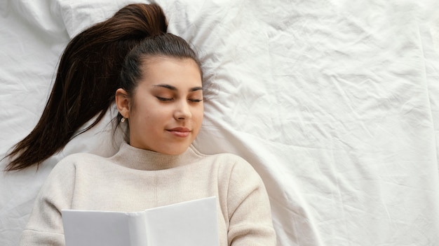 Gratis foto middellange geschoten vrouw in bed met boek