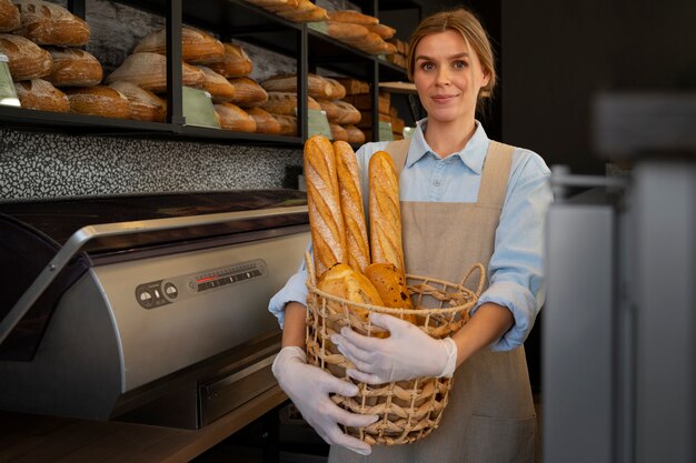 Middellange geschotene vrouw die in bakkerij werkt