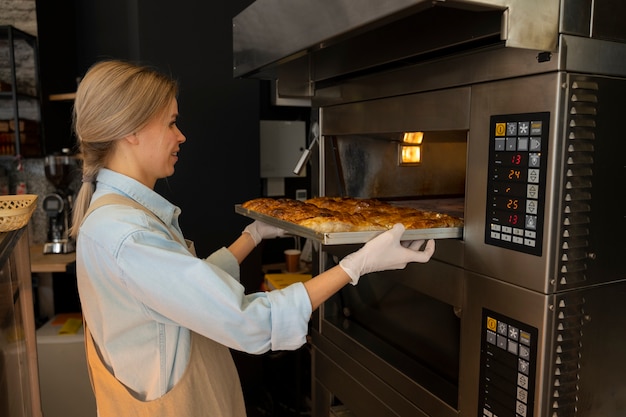 Middellange geschotene vrouw die in bakkerij werkt