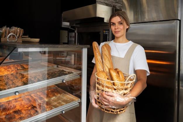 Middellange geschotene vrouw die in bakkerij werkt