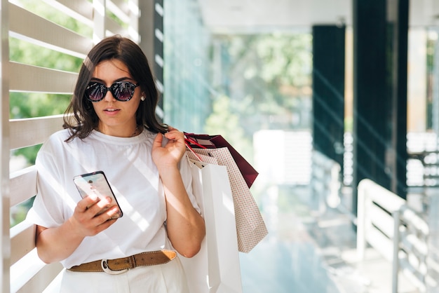 Middellange geschotene vrouw die op de telefoon kijkt