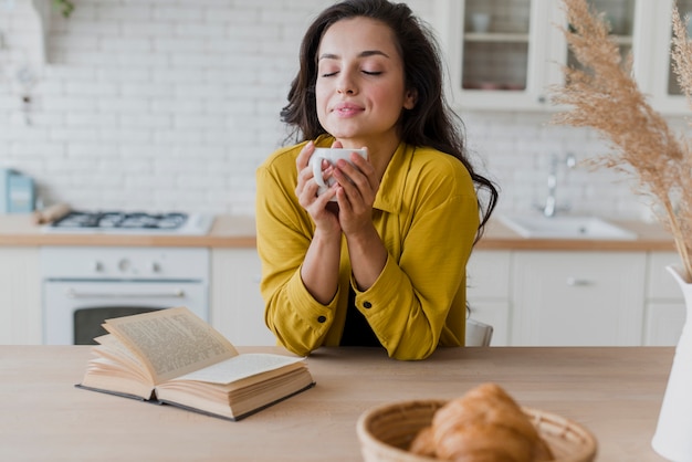 Middellange geschotene vrouw met kop en boek