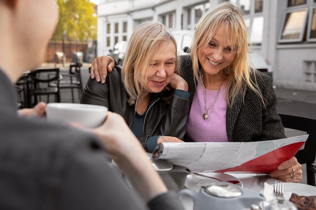 Gratis foto middellange geschotene vrouwen die bij restaurant zitten