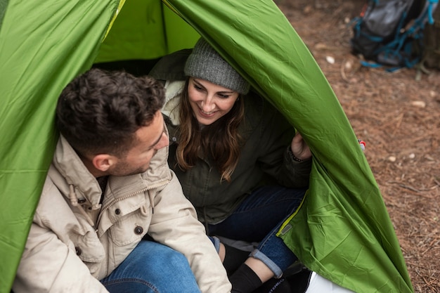 Middellange schot gelukkige mensen chatten in tent
