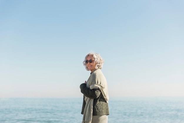 Middellange schot smiley oude vrouw op het strand