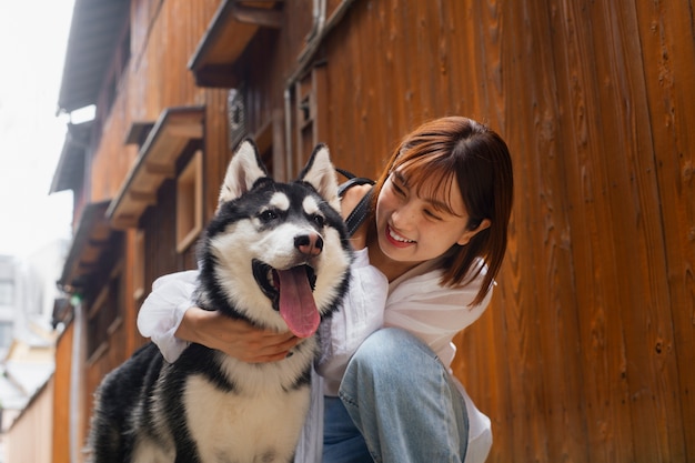 Gratis foto middellange shot aziatische vrouw met schattige hond