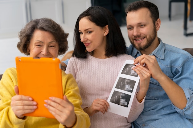 Gratis foto middellange shot gelukkige familie verwacht baby