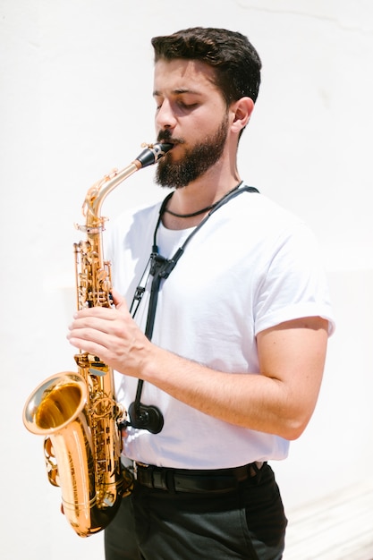 Gratis foto middellange shot gerichte muzikant die de sax speelt