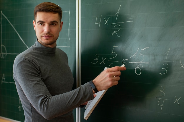 Gratis foto middellange shot jonge man die wiskunde onderwijst