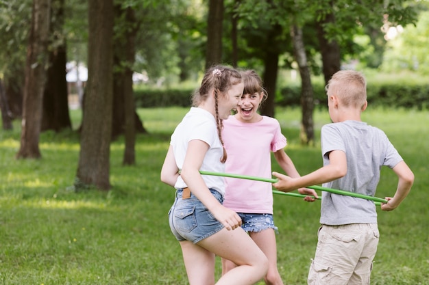 Middellange shot kinderen spelen samen met hoelahoep