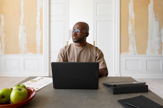 Gratis foto middellange shot man aan het werk op laptop