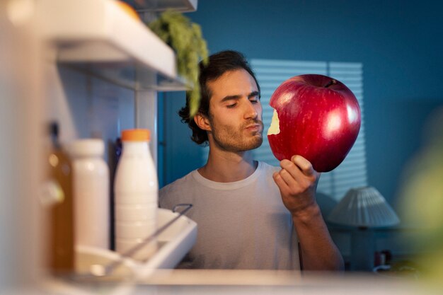 Middellange shot man die gigantische appel eet