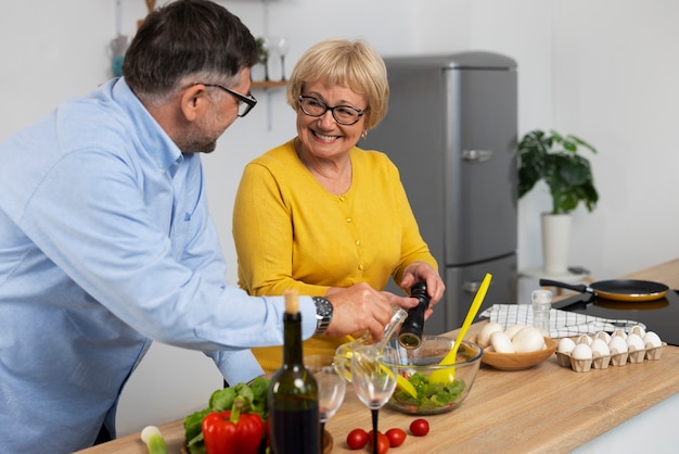 Gratis foto middellange shot man en vrouw koken in de keuken