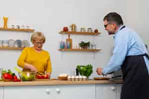 Gratis foto middellange shot man en vrouw koken in de keuken