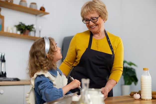 Gratis foto middellange shot oude vrouw en meisje in de keuken