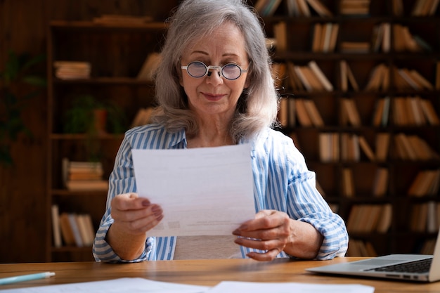 Middellange shot oude vrouw in bibliotheek