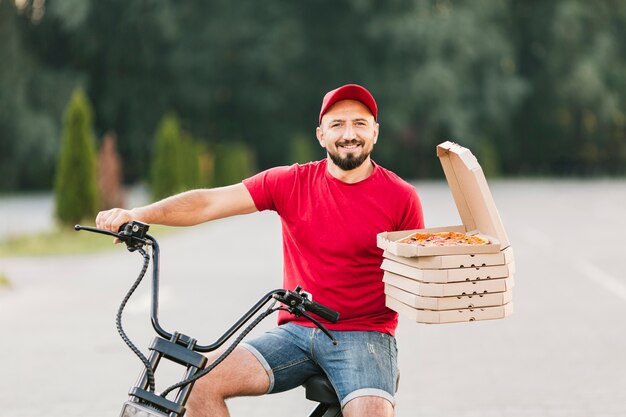 Middellange shot smiley bezorger op motorfiets