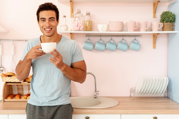 Middellange shot smiley man met kopje koffie