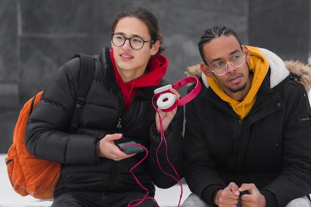 Gratis foto middellange shot vrienden met roze koptelefoon