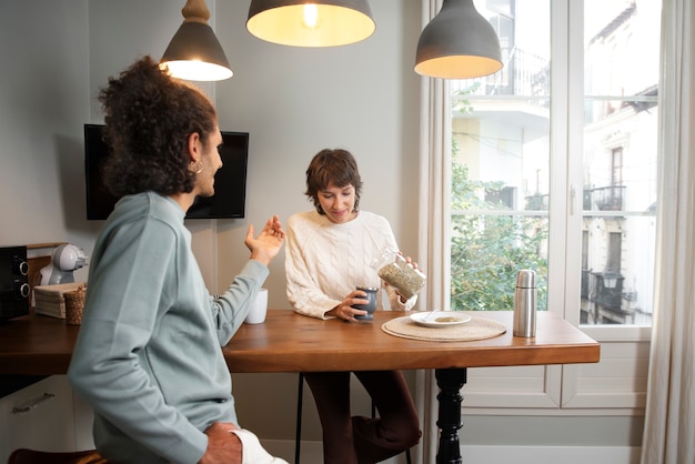 Gratis foto middellange shot vrienden zitten aan tafel