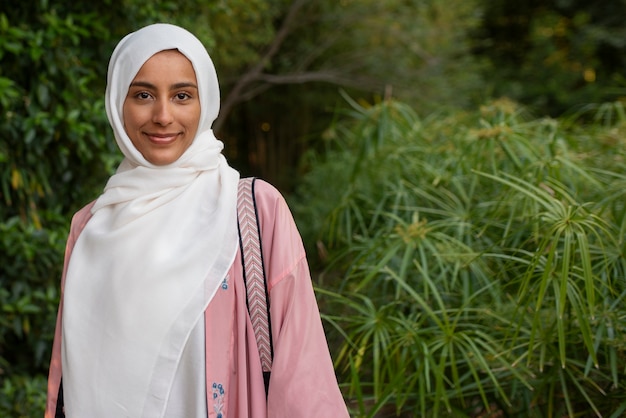 Gratis foto middellange shot vrouw die halal buitenshuis draagt