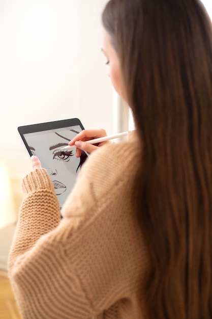 Middellange shot vrouw die in de ipad tekent