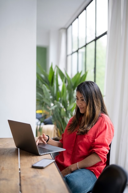 Gratis foto middellange shot vrouw die op laptop werkt