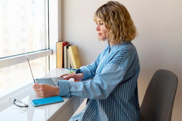 Middellange shot vrouw die op laptop werkt