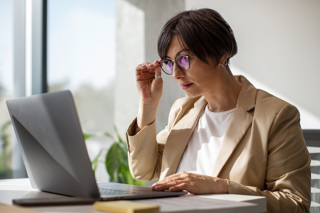 Gratis foto middellange shot vrouw die op laptop werkt