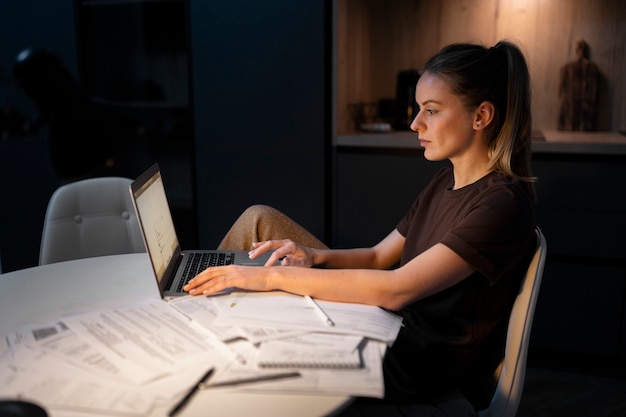 Middellange shot vrouw die op laptop werkt