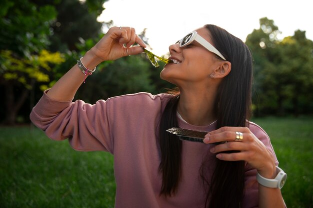 Middellange shot vrouw die zeewiersnack eet