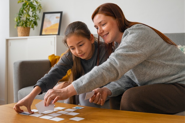 Middellange shot vrouw en meisje geheugenspel spelen