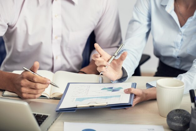 Middensectie van onherkenbare mensen in formalwear die statistische gegevens bespreken