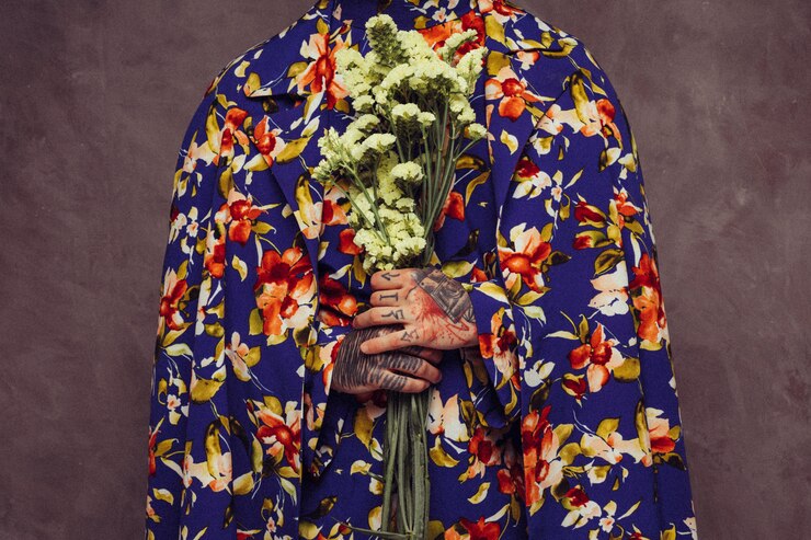 Gratis Foto midsection van een man met tatoeage in zijn hand met gele limonium bloem
