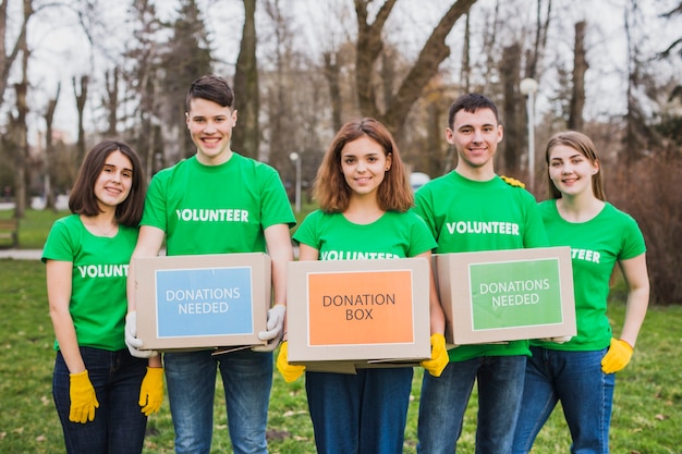 Milieu en vrijwilligersconcept met personen die dozen voor schenkingen houden