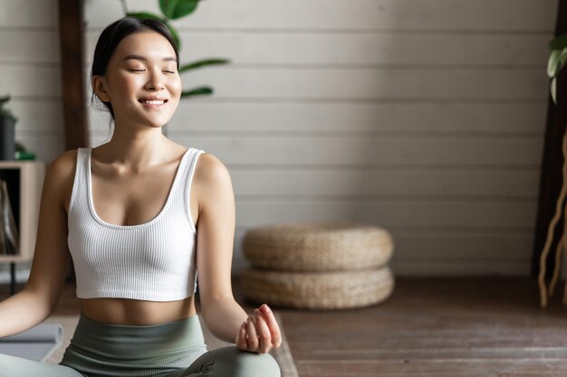 Mindfulness en meditatie concept jonge aziatische vrouw die thuis training doet yoga meditatie in het leven...