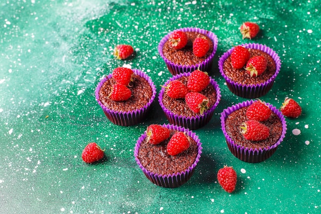 Gratis foto mini chocolade cupcakes met frambozen.