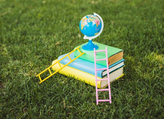 Mini globe bovenop stapel leerboek