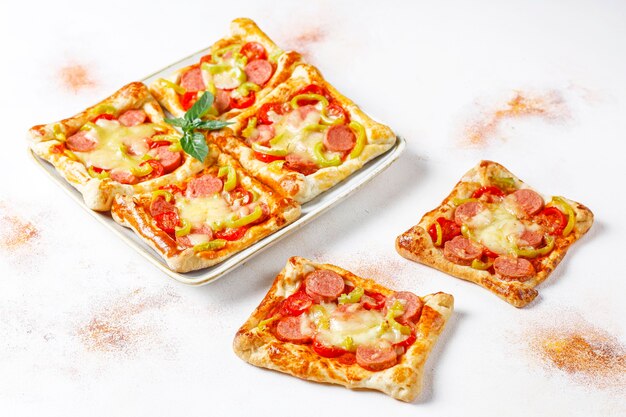 Mini-pizza's van bladerdeeg met worstjes.