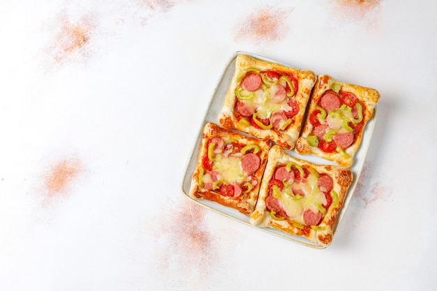 Mini-pizza's van bladerdeeg met worstjes.