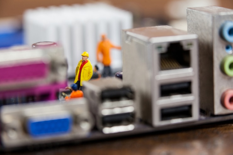 Gratis Foto miniatuur werknemers die op de chip van het moederbord